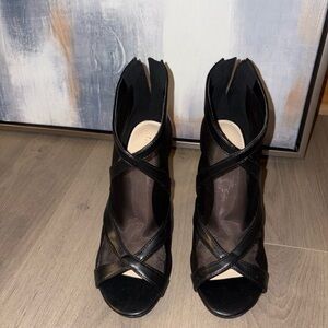 Black mesh ankle heels with leather trim and a stiletto heel.